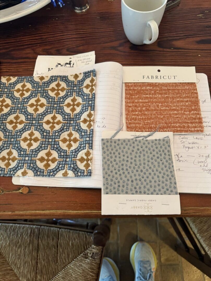 Fabric swatches on a notebook, table setting.