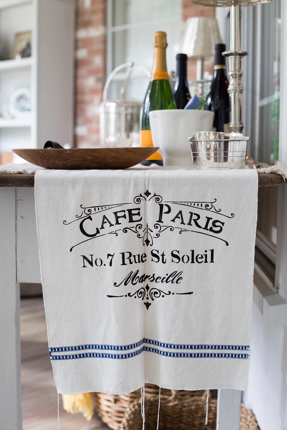 Café Paris towel with bottles on table.